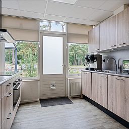 Moderne keuken in Groepsaccommodatie de Komeet in Dwingeloo, Zuidwest Drenthe, met uitzicht op de groene natuur.