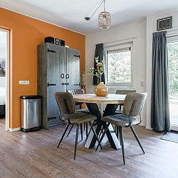 Gemuetlicher Innenbereich des Bungalows Jupiter in Dwingeloo, Drenthe, mit moderner Einrichtung und Blick auf die gruene Umgebung.