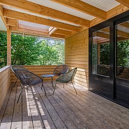Enjoy peace and quiet on the covered veranda of Heidelodge, a vacation home in green Dwingeloo, Southwest Drenthe.