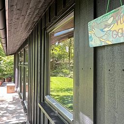 Detail van de buitenkant van Huisje in Dwingeloo, met naamplaatje en groene omgeving.