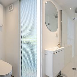 Der moderne Innenraum des Tiny House Eris mit Sauna in Dwingeloo, Drenthe, bietet durch grosse Fenster einen rustikalen Blick auf die Natur.