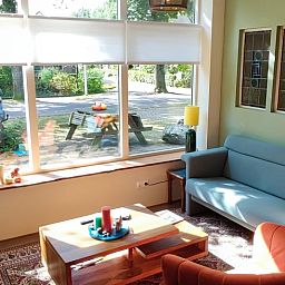 Charmante Terrasse am Ferienhaus in Dwingeloo, Suedwest-Drenthe, mit bequemen Stuehlen und Sonnenschirm.