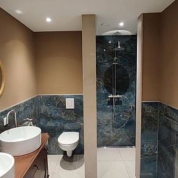 Stilvolles Badezimmer im Ferienhaus in Dwingeloo, Suedwest-Drenthe mit luxurioeser Dusche und Doppelwaschbecken.