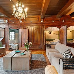 Gemuetliche Einrichtung des Ferienhauses in Ruinerwold, Drenthe, mit authentischem Kamin und gemuetlichem Bettgestell fuer einen stimmungsvollen Aufenthalt.