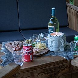 Geniessen Sie einen entspannten Abend auf der Veranda des Ferienhauses in Ruinerwold, einem Ferienhaus im Suedwesten von Drenthe, mit einer stimmungsvollen Snackplatte.