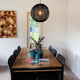 Gezellige eetruimte in chalet De Ganzenpoel, Zorgvlied, Zuidwest Drenthe, met moderne inrichting en uitzicht op de groene natuur.