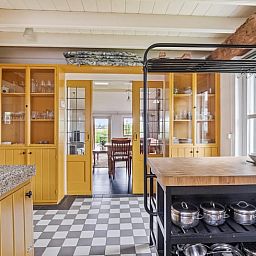 Stijlvolle keuken in Vakantiehuisje in Wapse, Zuidwest Drenthe, met houten elementen en uitzicht op eetruimte, ideaal voor een ontspannen verblijf.