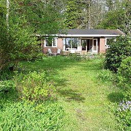 Front view of Cottage in Koekange, vacation home in Southwest Drenthe, surrounded by lush green garden.