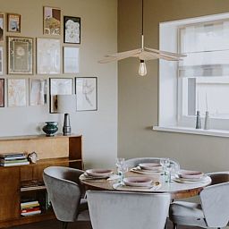 Stilvolles Esszimmer im Ferienhaus in Uffelte, Suedwest-Drenthe, mit Kunst an der Wand und modernen Moebeln.