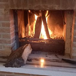 Gezellige open haard in Huisje in Elim, vakantiehuis in Elim, Zuidwest Drenthe, creeert een warme sfeer in de woonkamer.