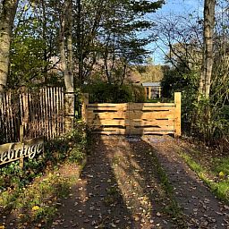Eingangstor des Ferienhauses in Ansen, Suedwest-Drenthe, umgeben von Natur.