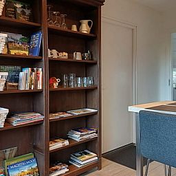 Boekenkast en eetgedeelte in Huisje in Veeningen, vakantieaccommodatie in Zuidwest Drenthe.