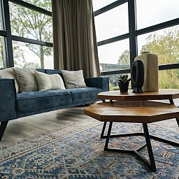 Cozy living room in the detached house in Biddinghuizen, Eastern Flevoland, with large windows and a comfortable sofa for relaxation.