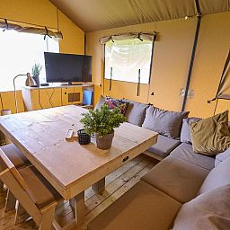Comfortable interior of Safari Tent Wood in Biddinghuizen with sitting area and plenty of natural light in Flevoland.