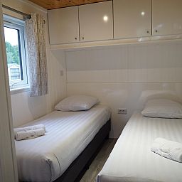 Sfeervolle slaapkamer in Vrijstaande woning in Biddinghuizen, Flevoland met twee comfortabele eenpersoonsbedden en uitzicht op de natuur.