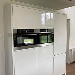 Moderne keukenapparatuur in Vakantiehuis Cube Elite 6, Biddinghuizen, Flevoland met ingebouwde ovens en strakke kasten.