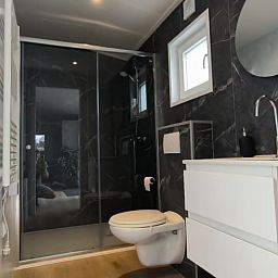 Geraeumiges Wohnzimmer im Ferienhaus FL088, Kraggenburg, mit moderner Einrichtung und Blick auf den gruenen Garten in Ost-Flevoland, Flevoland.