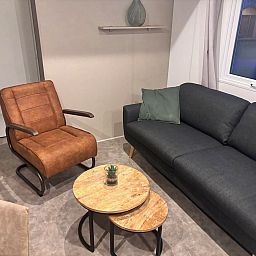 Gezellige woonkamer in Chalet de Krooneend, een stacaravan in Zeewolde, Flevoland, met comfortabele zitruimte en moderne inrichting.
