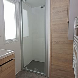 Moderne badkamer in Chalet de Krooneend, stacaravan in Zeewolde, Flevoland met stijlvolle douche en houten accenten.
