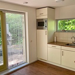 Moderne keuken in Huisje in Oudemirdum, vakantiehuis in Friese bossen, Friesland met uitzicht op groen.