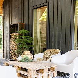 Relax on the porch of Huisje in Appelscha, a vacation home in the Frisian woods, Friesland, with a view of nature.