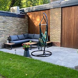 Gemuetliche Sitzecke auf der Terrasse des Ferienhauses in Appelscha, umgeben von der Natur des Friesenwaldes.