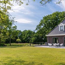 Ruim terras bij vakantiehuisje in Bakkeveen, Friesland, omgeven door natuur.