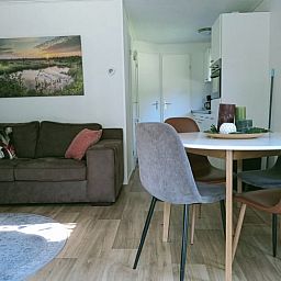 Gemuetliches Wohnzimmer des Ferienhauses in Oosterwolde, Friesland, mit bequemer Sitz- und Essecke in den friesischen Waeldern.