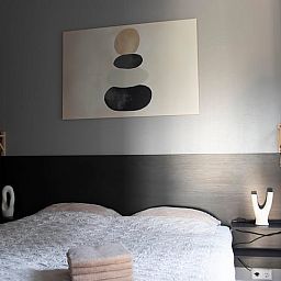 Attractive bedroom in a vacation home in Oosterwolde, Friesland, with modern artwork and comfortable furnishings in the Frisian forests.