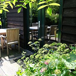 Buitenterras bij Vakantiehuisje in Boijl, ideaal voor een ontspannen maaltijd in de Friese bossen.