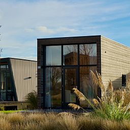 Vrijstaande woning in Hindeloopen, Friesland, biedt moderne vakantiehuiservaring met ruime ramen en natuurlijke omgeving.
