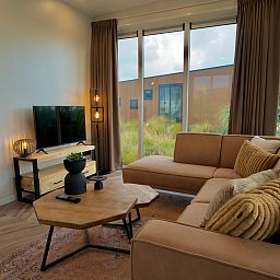 Modernes Wohnzimmer in einem freistehenden Haus in Hindeloopen, Ferienhaus in den friesischen Elfstdten, Friesland, mit komfortabler Einrichtung und Gartenblick.