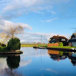 Rustgevend uitzicht vanaf Vakantiehuis in Idskenhuizen op het Friese platteland, met serene waterwegen en landelijke schoonheid.