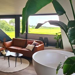 Ruime woonkamer in Vakantiehuisje in Westhem met groene omgeving, gelegen in het Friese platteland, Friesland.