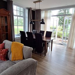 Gemuetlicher Innenbereich des Ferienhauses in Wijnaldum mit Esszimmer und Blick auf die friesische Landschaft.