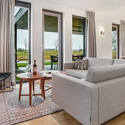 Gezellige woonkamer van 6-persoons woning 6C in Witmarsum, Friesland, met uitzicht op de natuur.