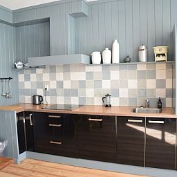 Moderne keuken in Vakantiehuisje in Munnekeburen, Friesland met houten werkblad en kleurrijke tegels.