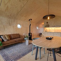 Gemuetliches Interieur des Ferienhauses in Broek, in der friesischen Landschaft, Friesland, mit moderner Einrichtung und Holzofen.