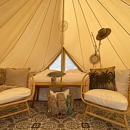 Binnenruimte van Vakantiehuis in De Hoeve, Friesland, gezellig ingericht met rieten stoelen.