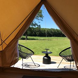 Uitzicht vanuit Vakantiehuis in De Hoeve over het Friese platteland, met moderne stoelen op het terras.