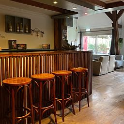 Gemuetliches Wohnzimmer im Ferienhaus in Hegebeintum, Friesland, mit bequemen Sofas und Holzboden.