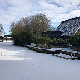 Winterlandschap bij Vakantiehuisje in Bartlehiem met besneeuwd kanaal op het Friese platteland.