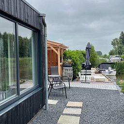 Moderne buitenruimte van Vakantiehuisje in Bartlehiem met uitzicht op het kanaal in Friesland.