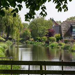 Rustikales Cottage in Echten, ein Ferienhaus in der friesischen Landschaft, umgeben von gruener Natur und einem ruhigen Wasserlauf.