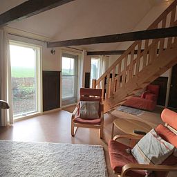 Gezellige woonkamer van Huisje in Readtsjerk, Friesland, met comfortabele stoelen en uitzicht op het Friese platteland.