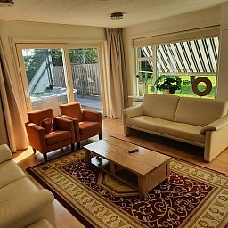 Gemuetliches Wohnzimmer des Ferienhauses in Oldelamer, Ferienhaus auf dem friesischen Land, mit grosszuegiger Sitzecke und Blick auf den Garten.