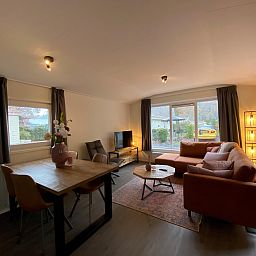 Gemtliches Wohnzimmer des freistehenden Hauses in Arnheim, Gelderland, mit komfortabler Sitzecke und Blick auf die grne Umgebung.