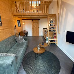 Gezellige binnenruimte van Vrijstaande woning in Arnhem, vakantiehuis in Rivierengebied, Gelderland met knusse zithoek en houten loft.