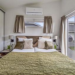 Schlafzimmer mit Doppelbett in Natur Lodge 4 Personen Wellness, Aalst, Gelderland, bietet Komfort und Ruhe.