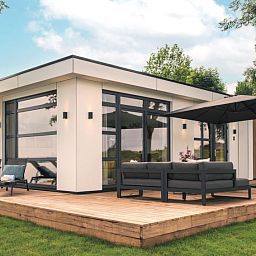 Stijlvol terras bij Vakantiehuis MarinaPark Bad Nederrijn in Maurik, Gelderland, met comfortabele zitplaatsen en parasol.